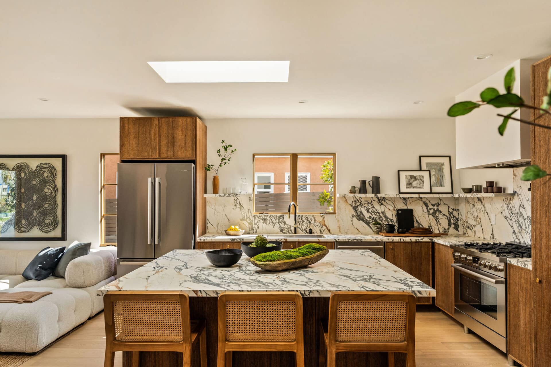 View of the kitchen featuring marble countertop, backsplash and shelf.